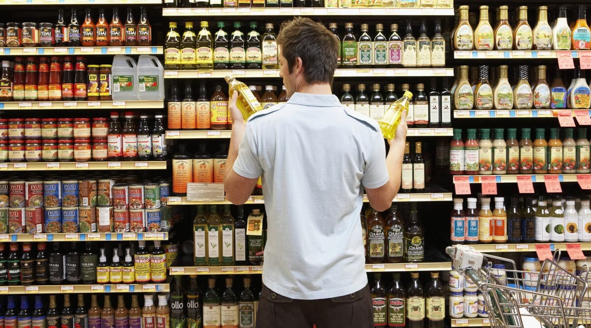 Mann vergleicht im Supermarkt die Preise