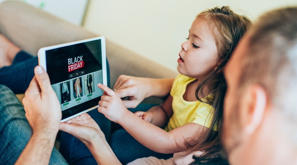 Vater und Tochter suchen gemeinsam nach Rabattten zum Black Friday